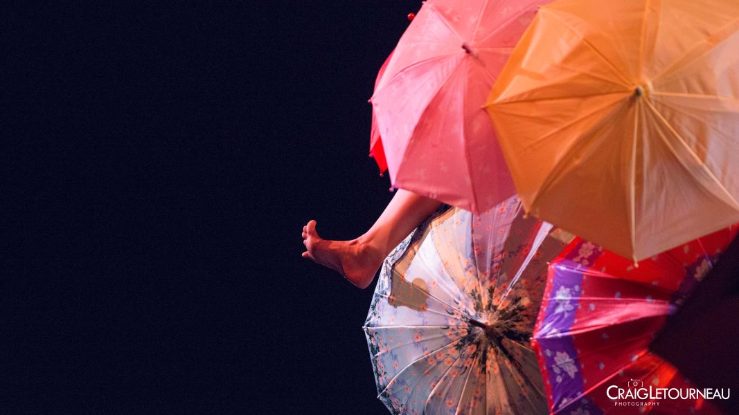 foot appearing through a cluster of umbrellas